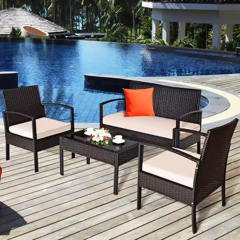 Juego de muebles de conversación de ratán para patio Costway de 4 piezas con asiento acolchado y mesa de cristal