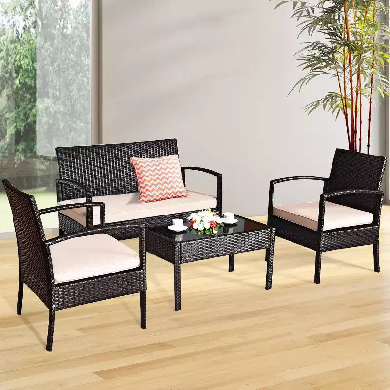 Juego de muebles de conversación de ratán para patio Costway de 4 piezas con asiento acolchado y mesa de cristal